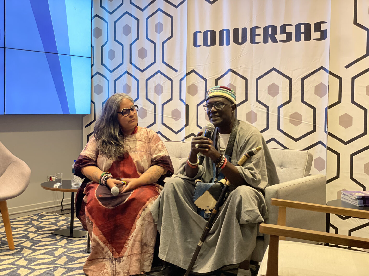 Ana Camila conducts conversation with Moussa Sene Absa (Mamadou Diop)